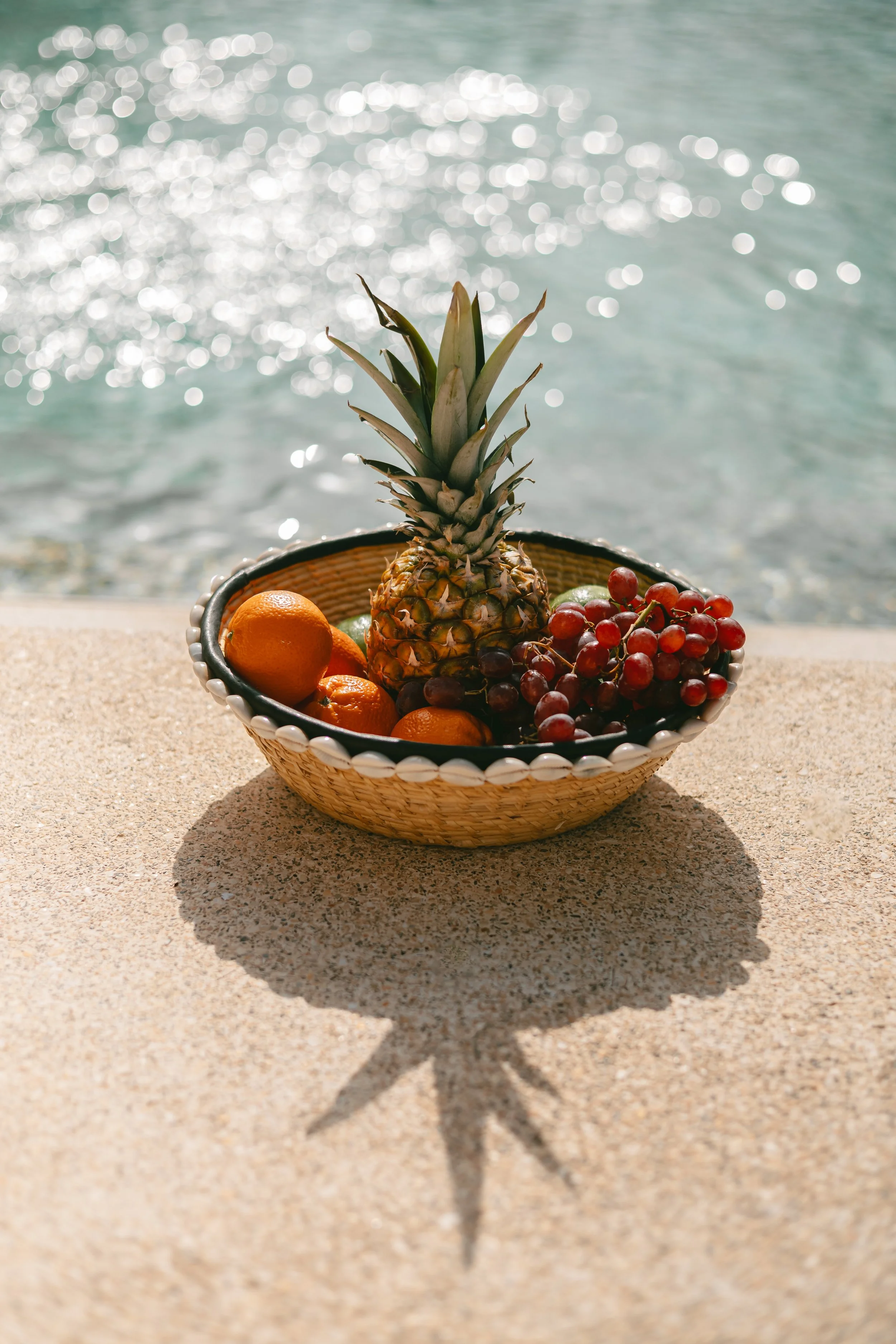 Corbeille d'ananas, raisins et clémentines au bord de la piscine